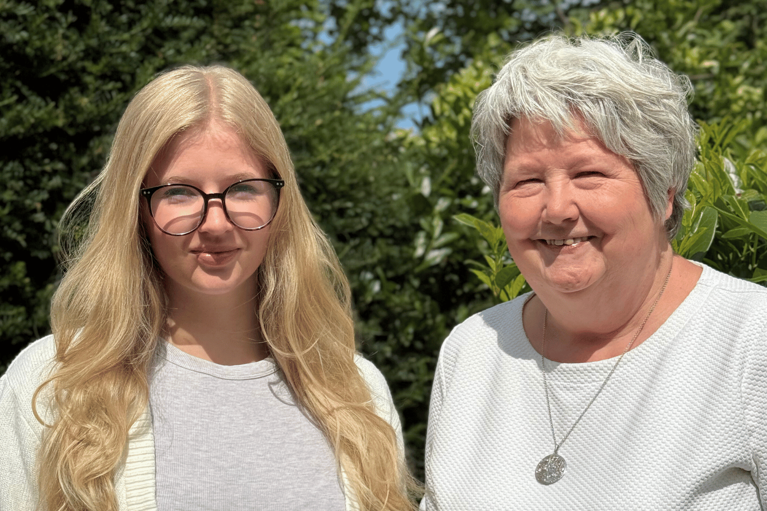 Das Bild zeigt eine junge Frau mit blonden langen Haaren und Brille neben einer älteren Frau mit kurzen grauen Haaren.Es wird die neue Auszubildende vorgestellt neben der Personalchefin.