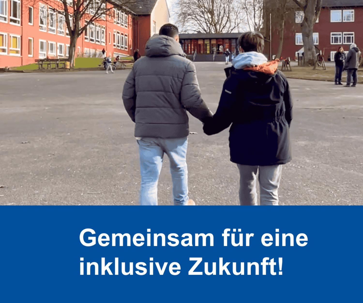 Ein Schulbegleiter der Familien-und Krankenpflege Bochum geht Hand in Hand mit seinem Schulkind über en Schulhof. Wir sehen die beiden Personen von hinten, im Hintergrund sehen wir das Schulgebäude und den Schulhof